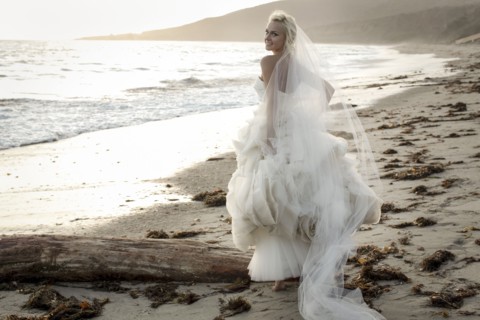 Caucasian bride walking on beach