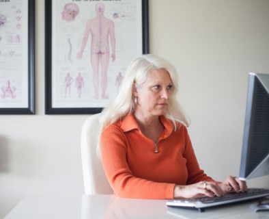 Caucasian chiropractor working at computer