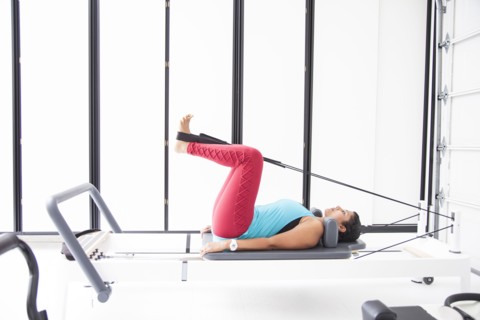 Asian woman using exercise machine in gymnasium