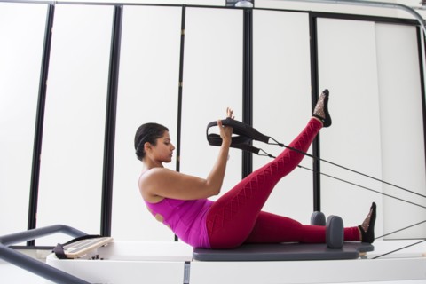 Asian woman using exercise machine in gymnasium