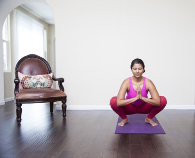 Asian woman practicing yoga in living room
