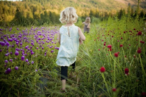 Girl walking in rural field of flowers
