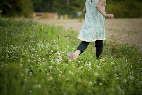 Girl walking in field of flowers