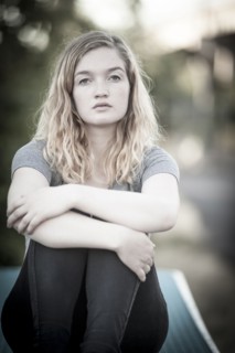 Serious woman hugging her knees