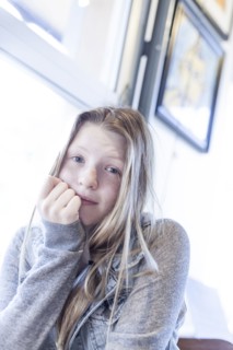 Serious girl resting chin in hand