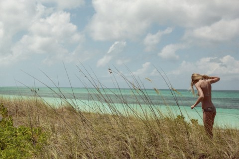 Woman in bikini standing in beach grass