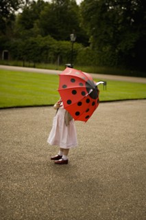 Girl standing under umbrella in park