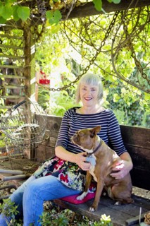 Older Caucasian woman petting dog in garden