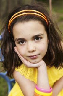 Close up of pensive girl resting chin in hand