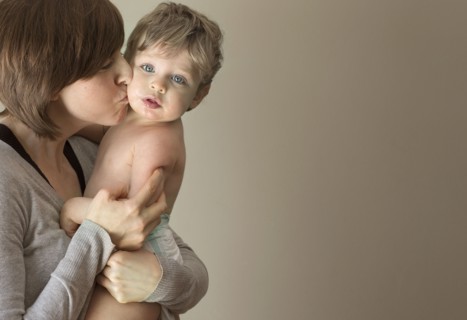 Close up of woman kissing son on cheek