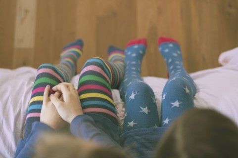 High angle view of Caucasian sisters wearing colorful tights