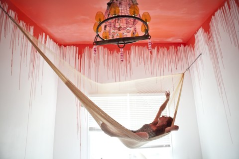 Caucasian woman laying in hammock under dripping ceiling