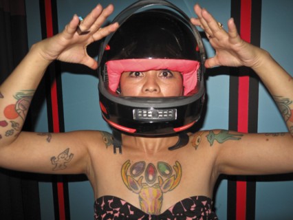 Asian woman with tattoos wearing motorcycle helmet