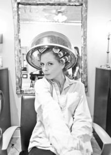 Woman sitting under hair dryer in salon