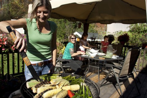 Woman grilling vegetables on patio