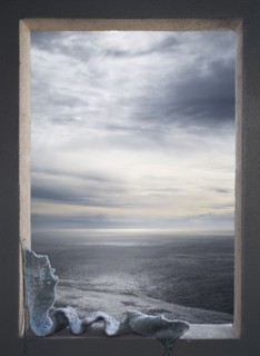 Knitted scarf in window over seascape