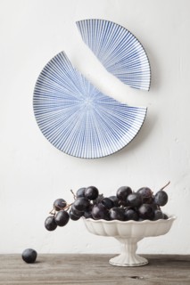 Grapes on platter under broken ceramic plate