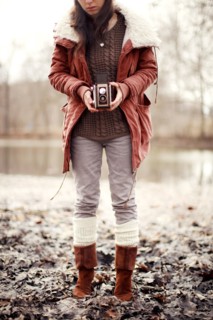 Caucasian woman photographing with vintage camera near rural pond