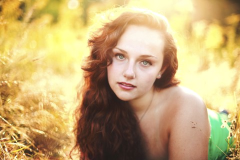 Close up of woman laying in tall grass