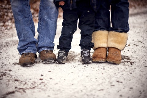Close up of boots of family standing in snow