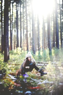 Woman sitting on log in forest
