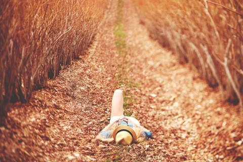 Caucasian woman laying on dirt path