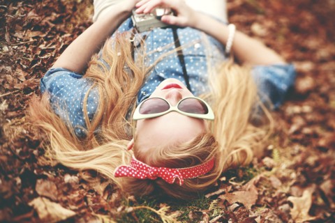 Caucasian woman laying in autumn leaves