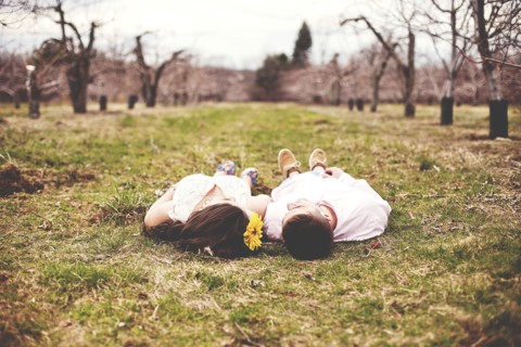 Couple laying on dirt path in vineyard