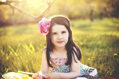 Girl playing with pinwheel in rural field