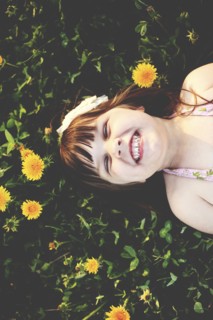 Smiling girl laying in grass with flowers