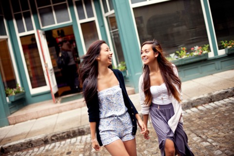 Laughing women crossing cobblestone street