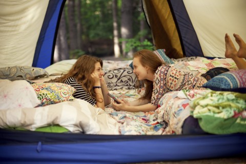 Girls relaxing in camping tent