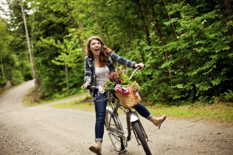 Girl riding bicycle on dirt path