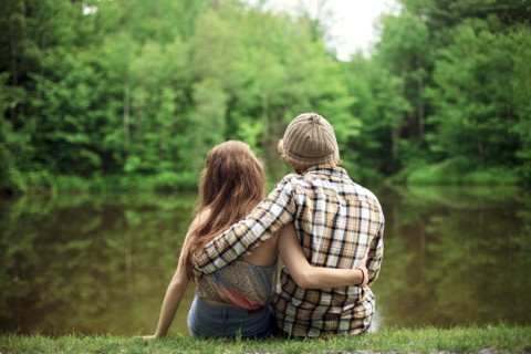 Rear view of couple hugging near lake