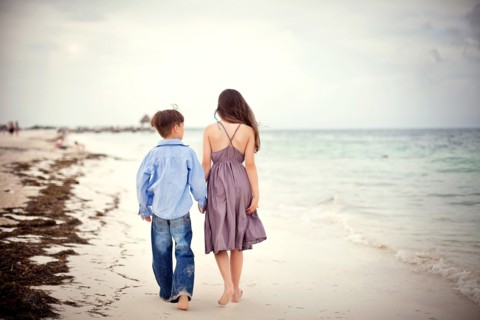 Brother and sister walking on beach