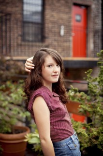 Teenage girl standing on urban rooftop