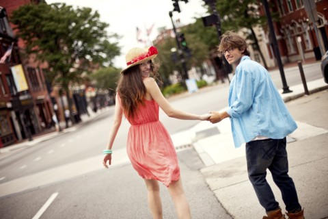Rear view of couple walking on city sidewalk