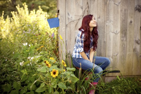 Gardener sitting near wooden shed in backyard