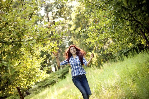 Girl walking in tall grass in rural field