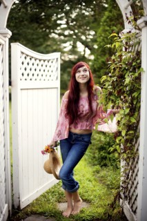 Girl carrying straw hat in garden