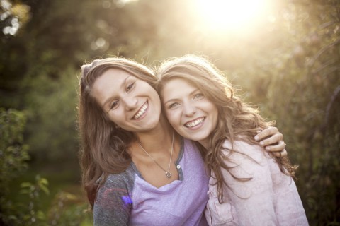Smiling women hugging in rural field