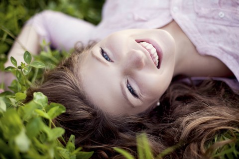 Smiling woman laying in grass