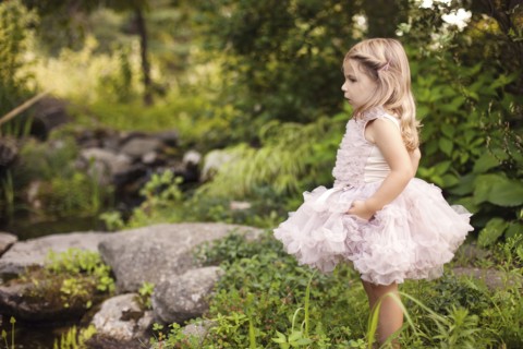 Girl in frilly dress exploring creek