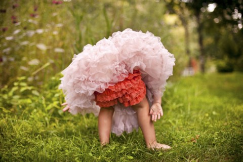Girl wearing frilly dress in garden