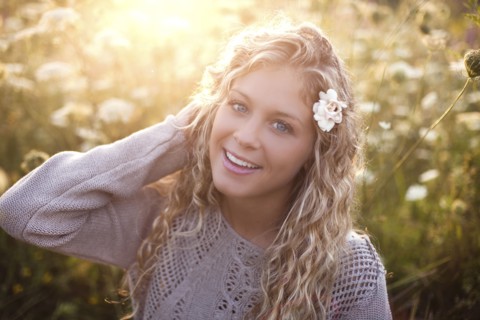 Woman sitting in tall flowers