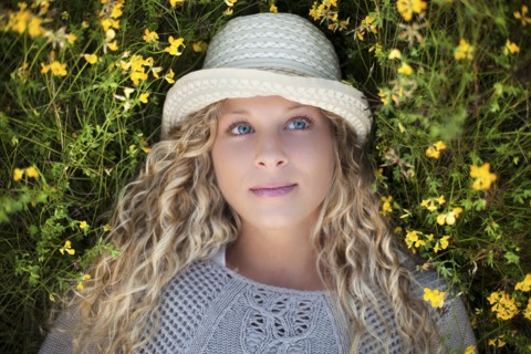 Woman in straw hat laying in flowers