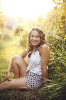 Smiling woman sitting in rural field