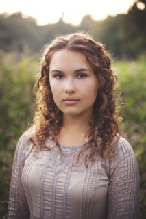 Serious woman standing in rural field