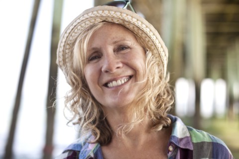 Caucasian woman standing under boardwalk on beach
