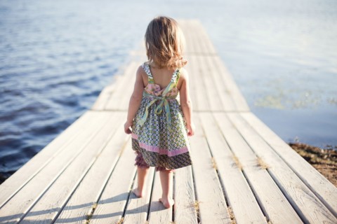 Girl walking on wooden dock over rural lake